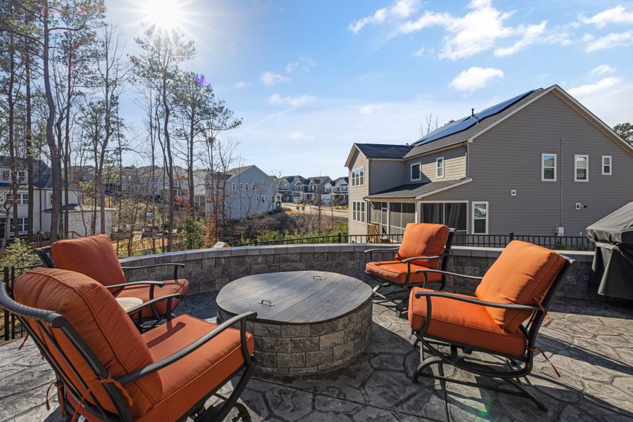 A stamped concrete rear patio in an ashlar slate pattern wrapping a seating area and fire pit