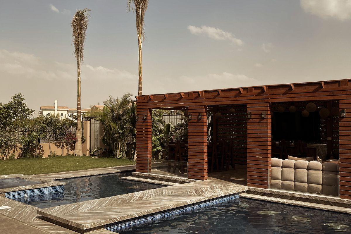 Sawn stone pool deck running under a cedar shade structure