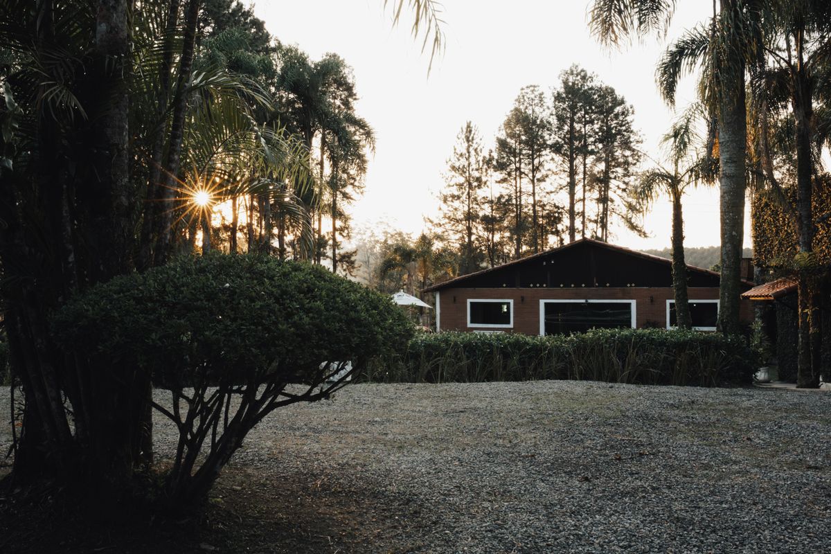 Crushed stone turnaround court in front of a low ranch house at dusk