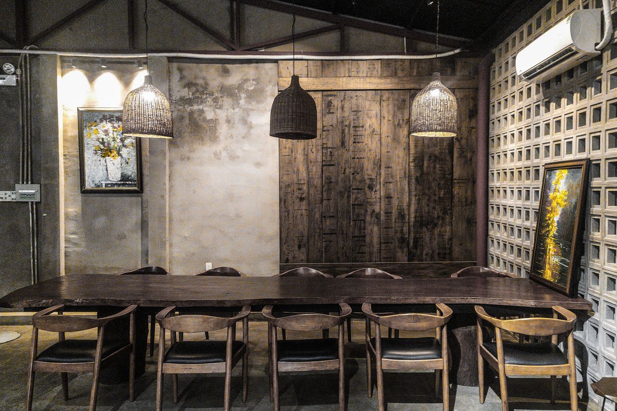 Long timber table set for twenty under low pendant lights